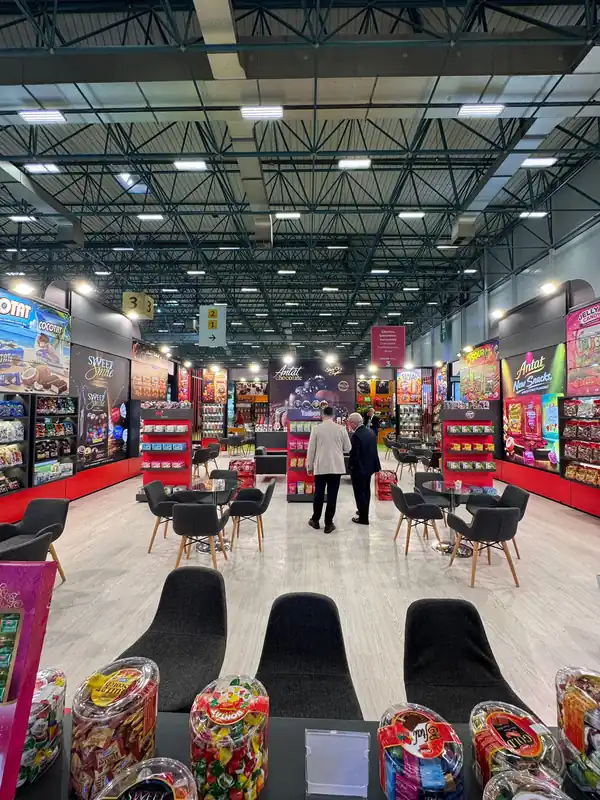 Stand zeminindeki siyah karo halıların endüstriyel vakum makinesi ile tozdan ve kirden arındırılması anı